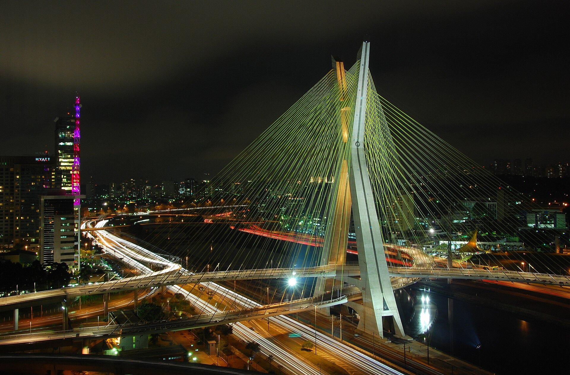 Cidade brasileira conectada à noite, com trilhas de luz nas avenidas